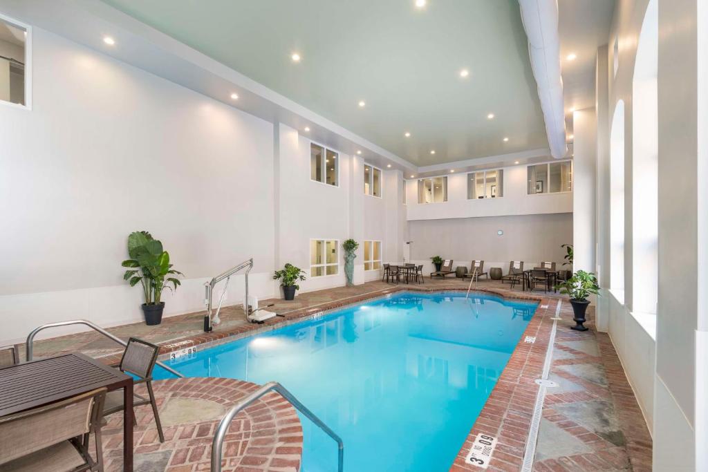 ein großer Pool in einem Hotel mit Tischen und Stühlen in der Unterkunft Homewood Suites by Hilton New Orleans in New Orleans