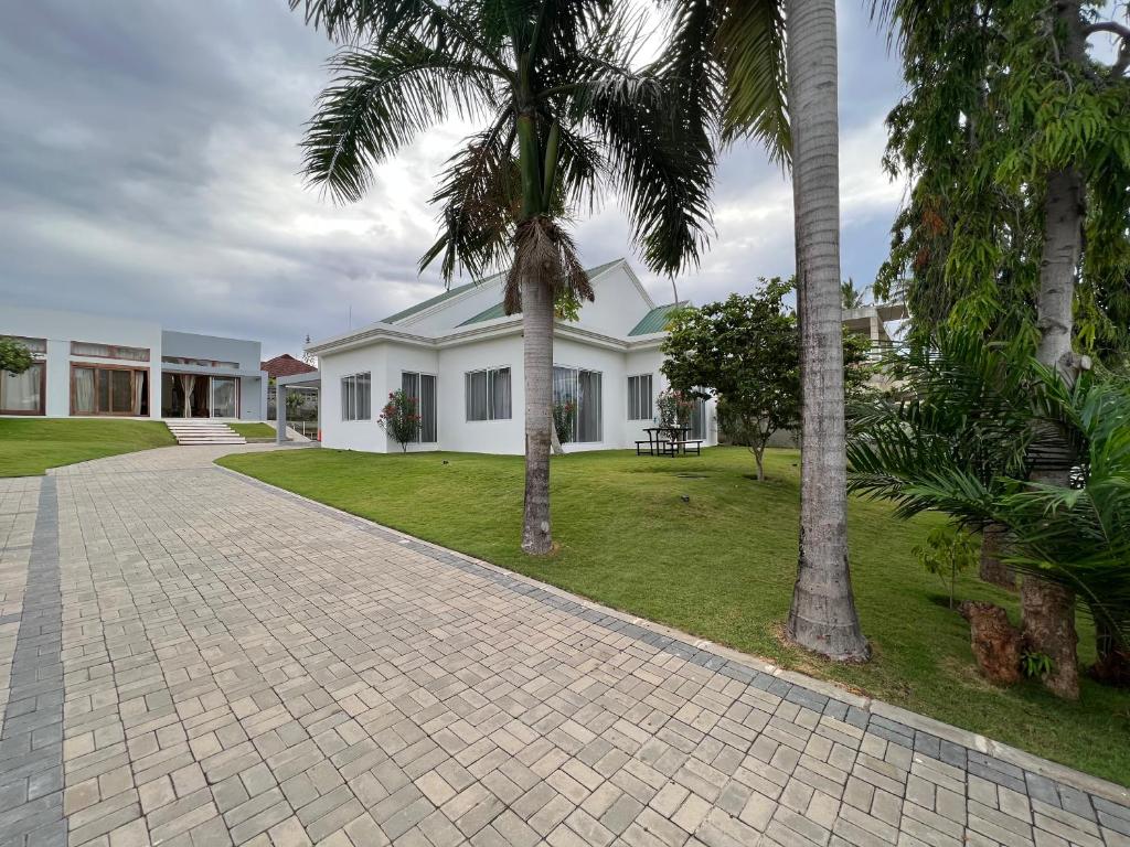 una casa con palme e un vialetto di mattoni di Datela Home - 3Bed Villa near Ununio Beach Kunduchi a Dar es Salaam