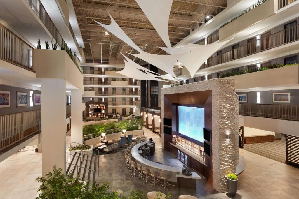 a lobby with a large television in a building at Embassy Suites by Hilton Atlanta Airport in Atlanta