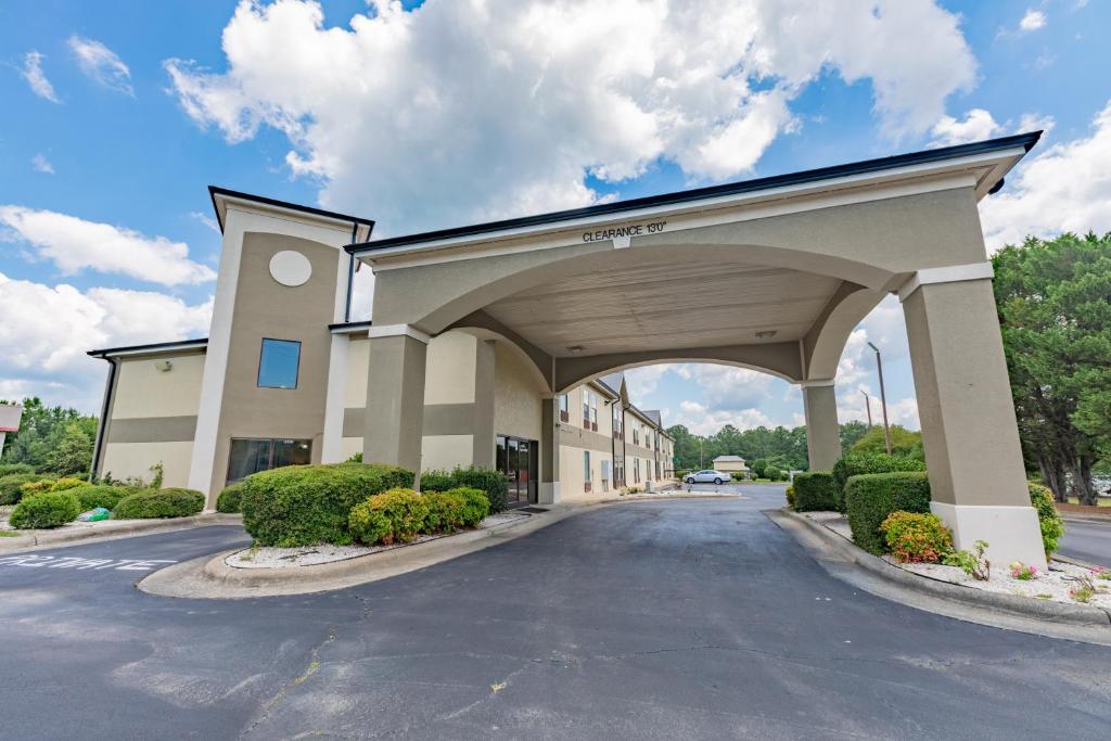 a large building with an arch over a street at Baymont by Wyndham Creedmoor in Creedmoor