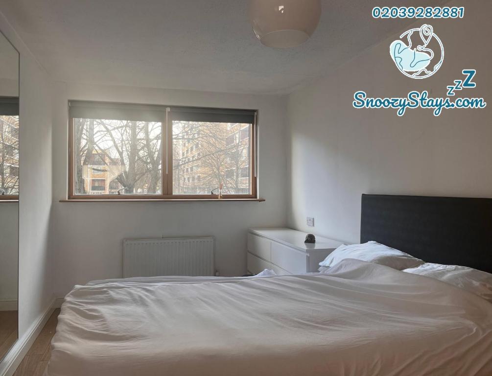 a bedroom with a white bed and a window at Charming Central London Apartment with Balcony in London
