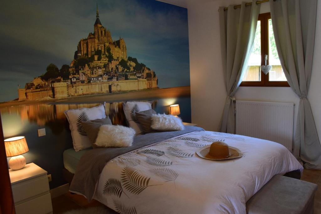 a bedroom with a bed with a castle mural on the wall at Baie du Mont Saint Michel, optez pour notre "Plan Baie" in Saint-Jean-le-Thomas