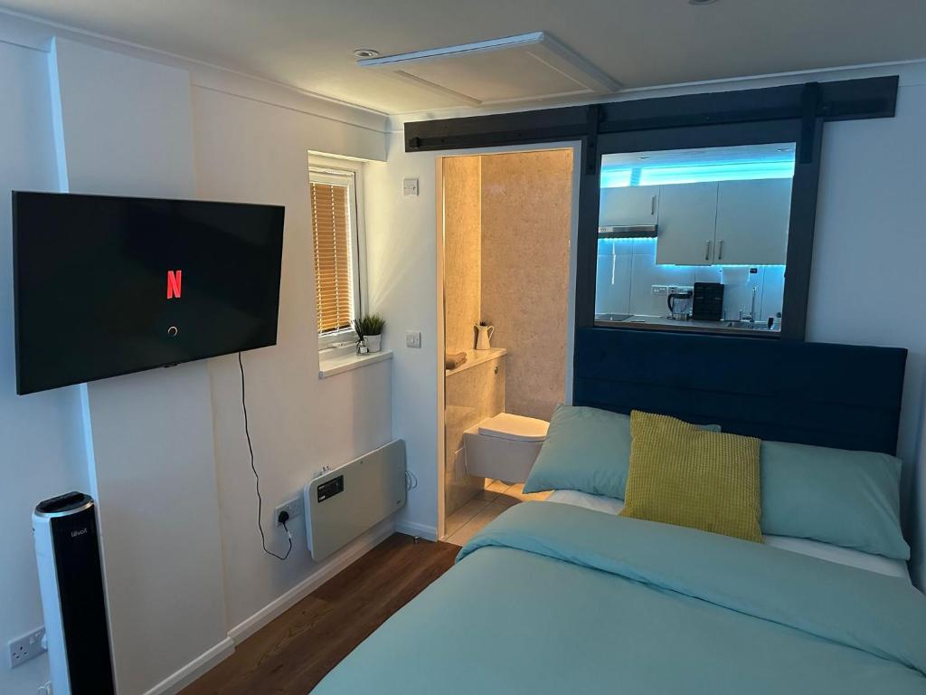 1 dormitorio con 1 cama y TV de pantalla plana en Nice and Cosy Studio, en Bristol