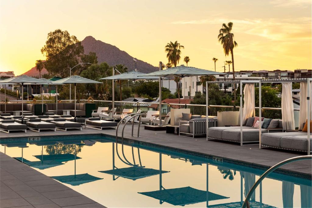 a swimming pool with lounge chairs and a resort at Senna House Hotel Scottsdale, Curio Collection By Hilton in Scottsdale