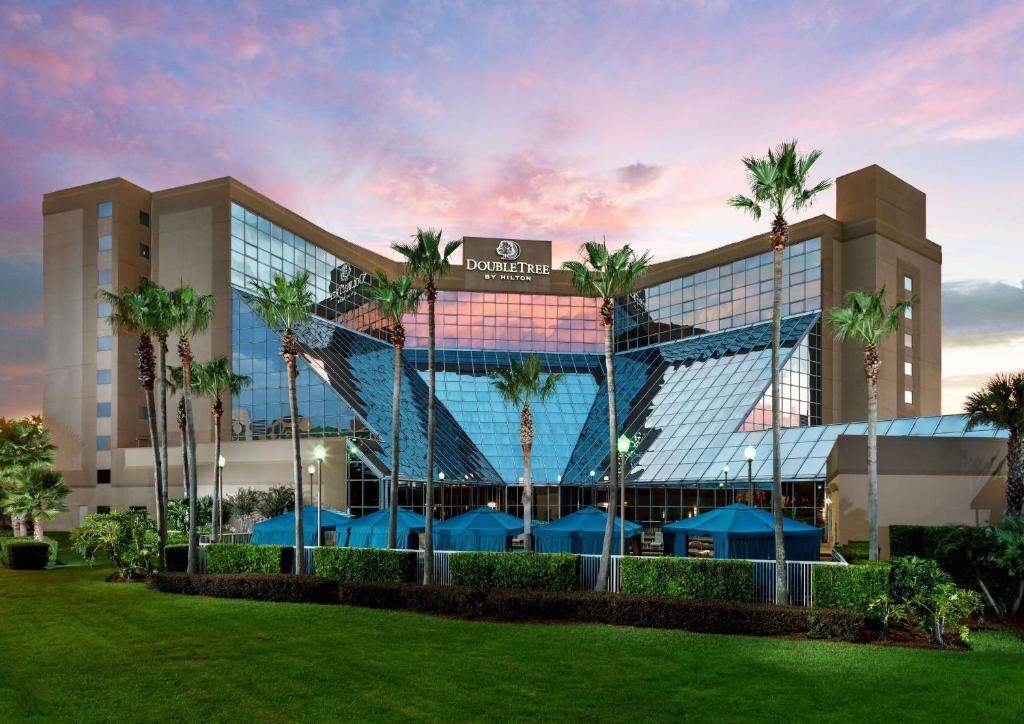 eine Darstellung der Vorderseite eines Hotels mit Palmen in der Unterkunft DoubleTree by Hilton Orlando Airport Hotel in Orlando