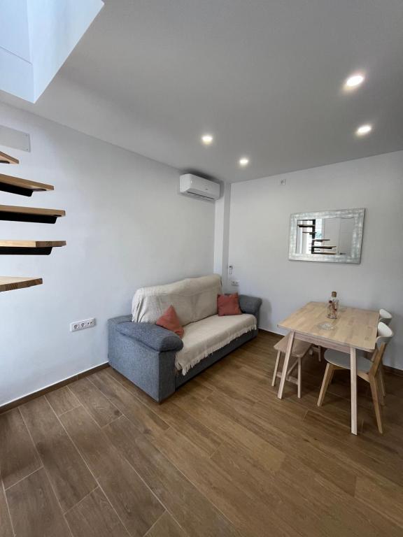 ein Wohnzimmer mit einem Sofa und einem Tisch in der Unterkunft Duplex Triana III in Bolonia