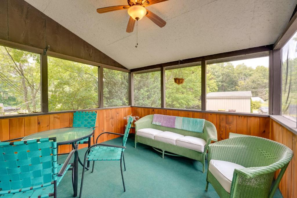 un porche cubierto con sofá y sillas en Pet-Friendly Queensbury Home with Screened Porch en Queensbury