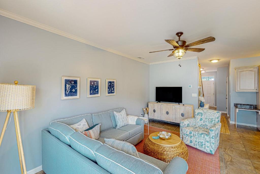 a living room with a blue couch and a tv at The Tides --- 19979 Sandy Bottom Cir, Unit #502 in Rehoboth Beach