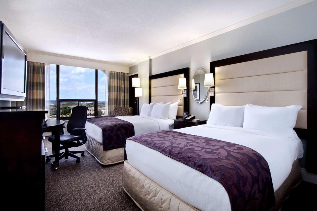 a hotel room with two beds and a desk at Hilton Springfield in Springfield