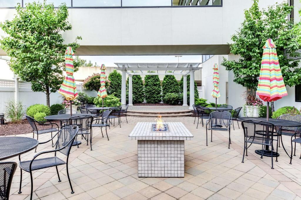 un patio al aire libre con mesas y sillas y un patio en DoubleTree by Hilton Binghamton, en Binghamton