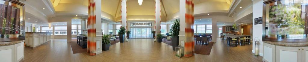 a large lobby with tables and chairs in a building at Hilton Garden Inn Atlanta East/Stonecrest in Lithonia