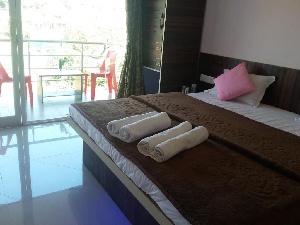a hotel room with two beds with towels on them at ROYAL HERITAGE in Mahabaleshwar
