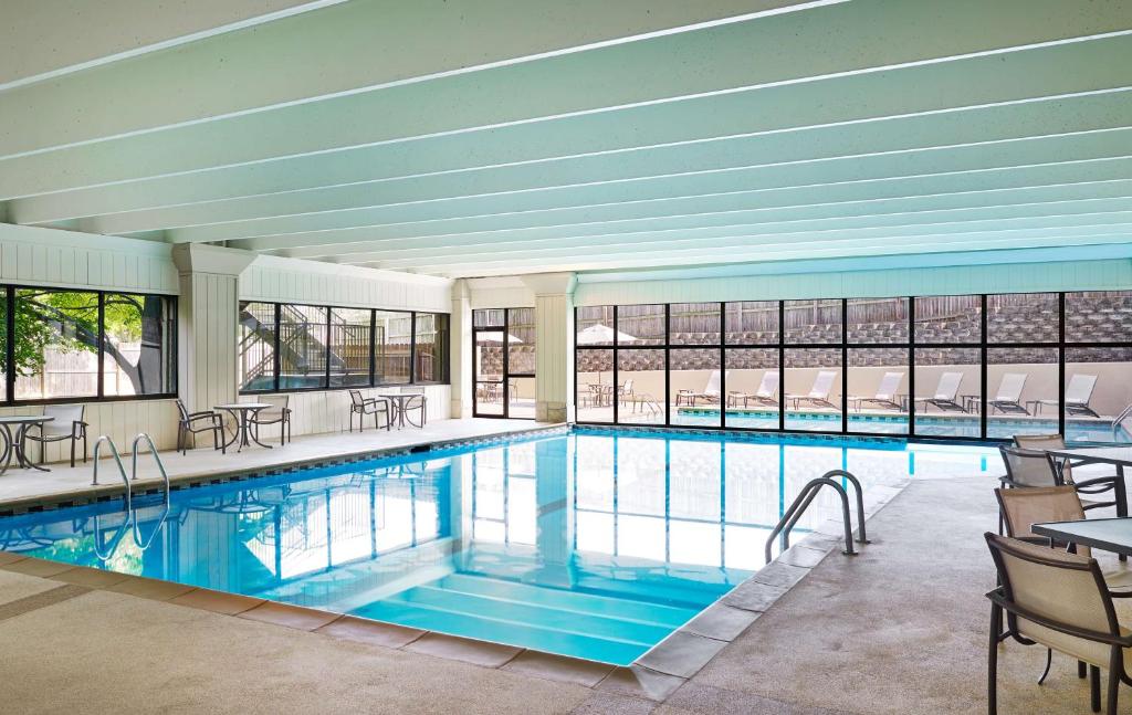 堪薩斯城的住宿－希爾頓堪薩斯城機場酒店，大楼内带桌椅的大型游泳池