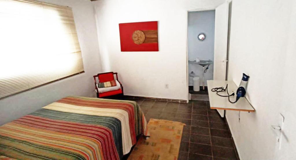 a bedroom with a bed and a bathroom with a sink at Loft em Souzas in Joaquim Egídio