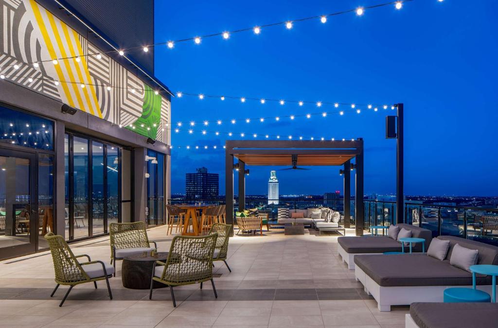 um pátio no último piso com vista para a cidade à noite em Hilton Garden Inn Austin University Capitol District em Austin