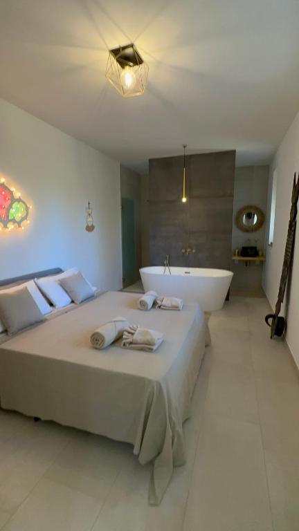 a bedroom with a large bed and a bath tub at Il Gelsomino luxury suites in Bari