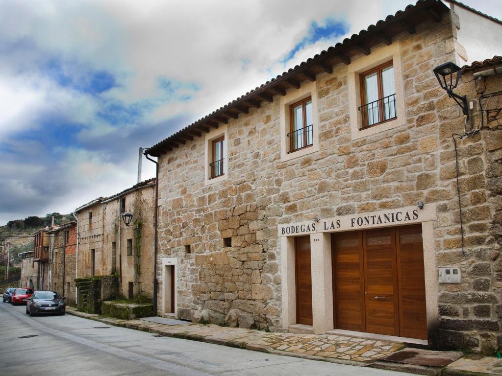 a stone building with a wooden door on a street at La Casa del Vino in Fermoselle