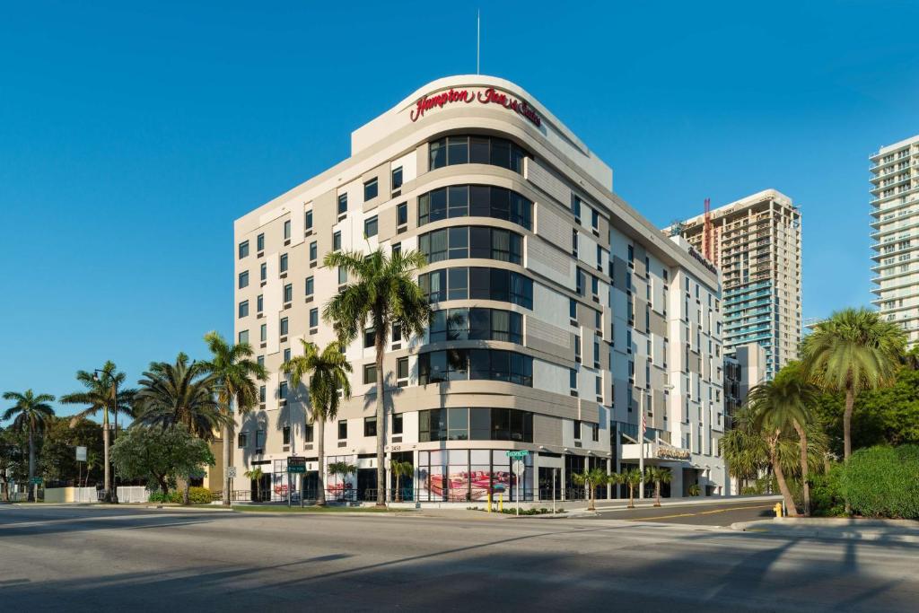 un edificio alto y blanco con palmeras delante en Hampton Inn & Suites Miami Wynwood Design District, FL en Miami