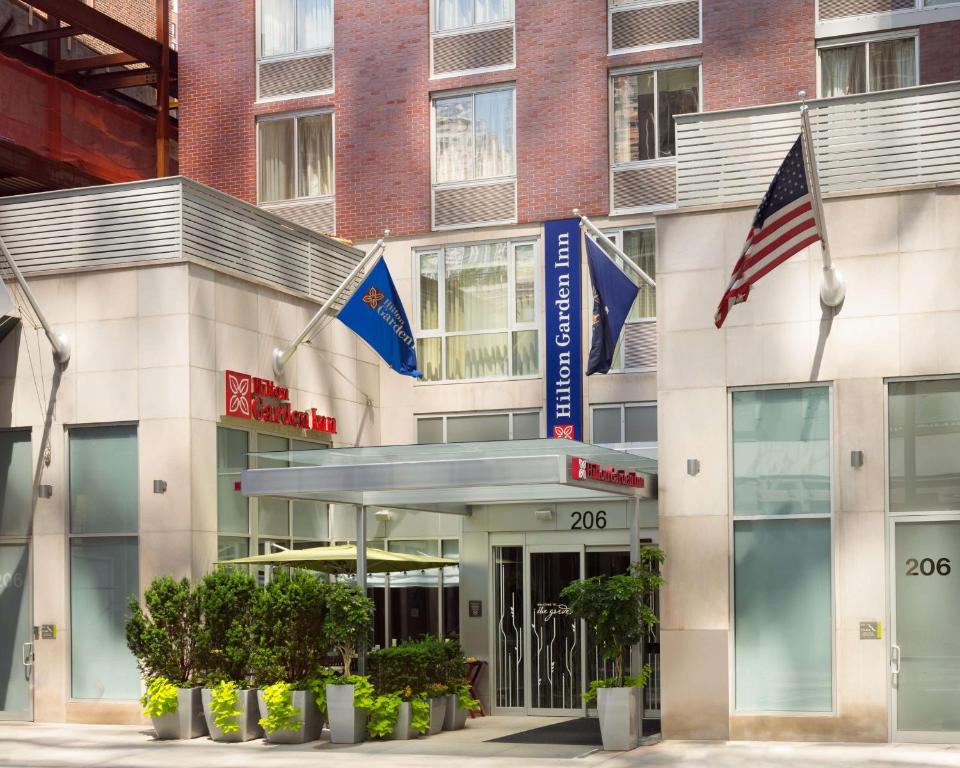 un edificio de oficinas con banderas delante en Hilton Garden Inn New York Manhattan Midtown East, en Nueva York