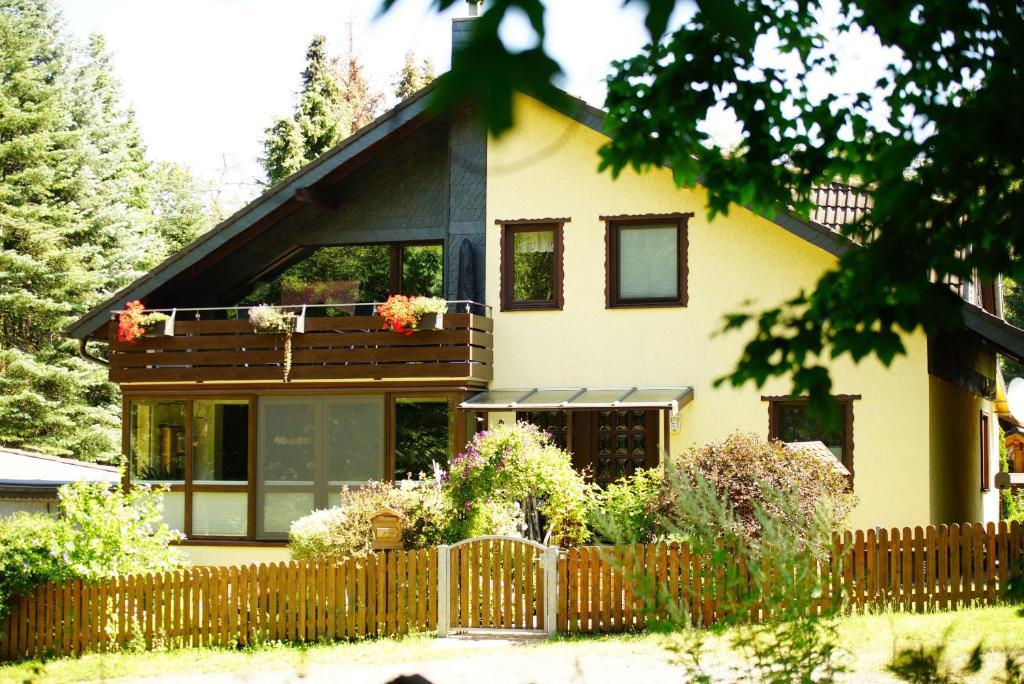 a house with a fence in front of it at 4-Personen-Ferienwohnung-im-Wald-mit-Kamin-84-Qudratmeter in Bad Harzburg