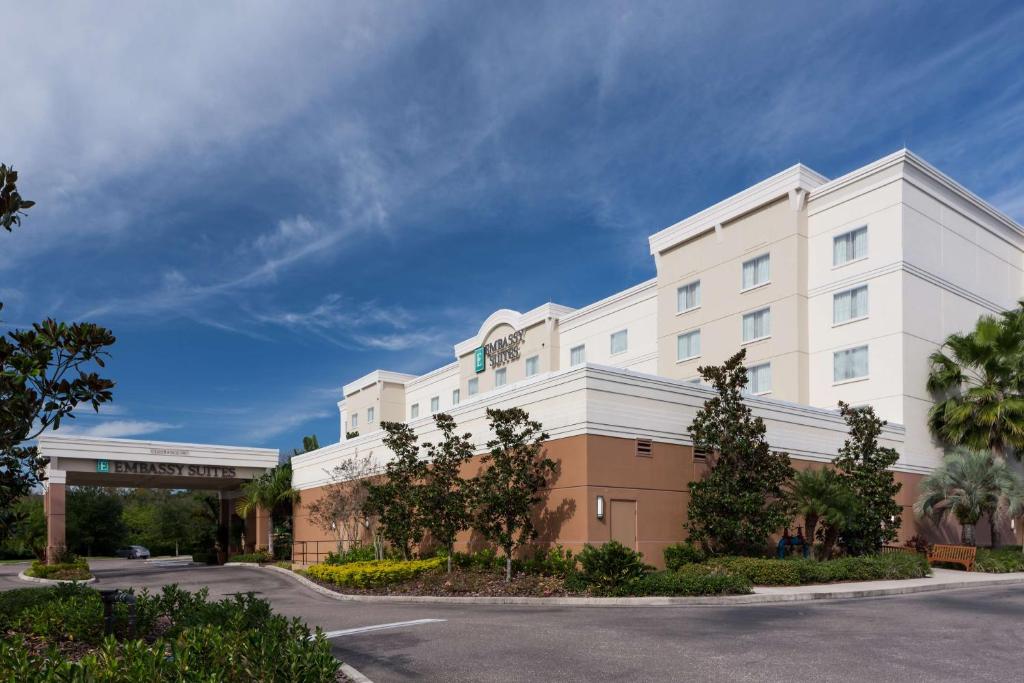 a large white building with a clock on it at Embassy Suites by Hilton Tampa Brandon in Tampa
