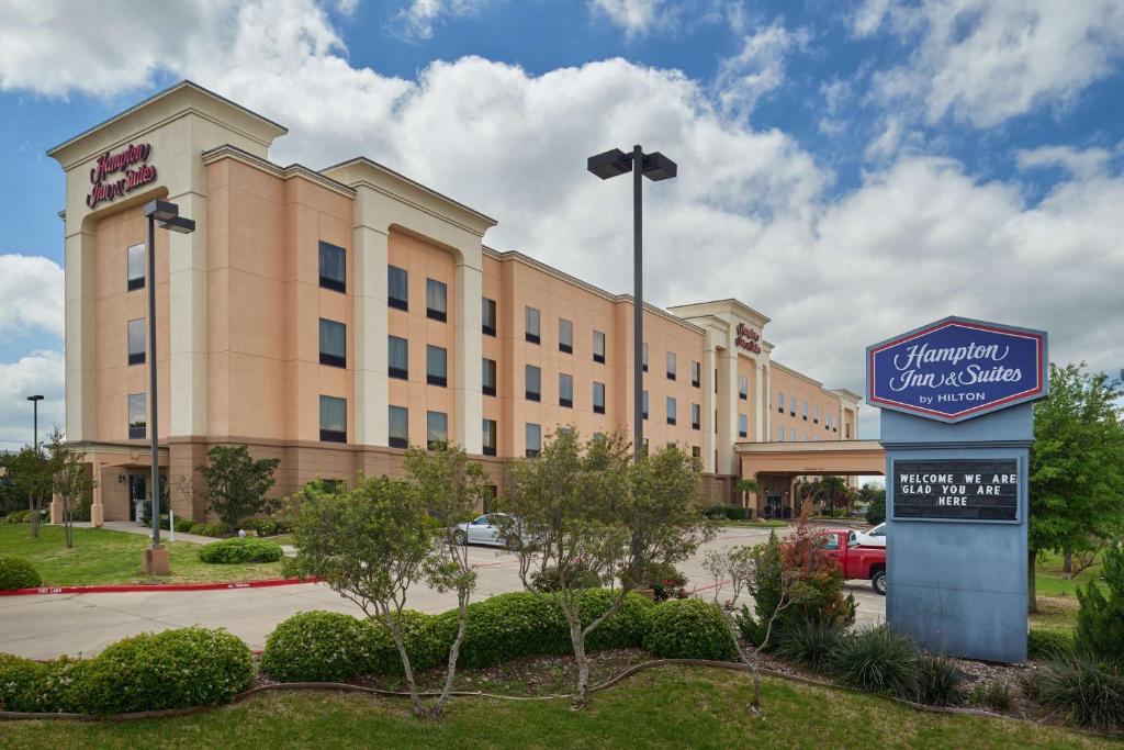 un hôtel avec un panneau devant un bâtiment dans l'établissement Hampton Inn & Suites Waco-South, à Waco