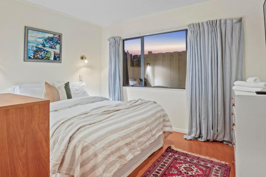 a bedroom with a bed and a large window at Taupo Beachfront Escape 12min to Town - Free Wifi in Waitahanui