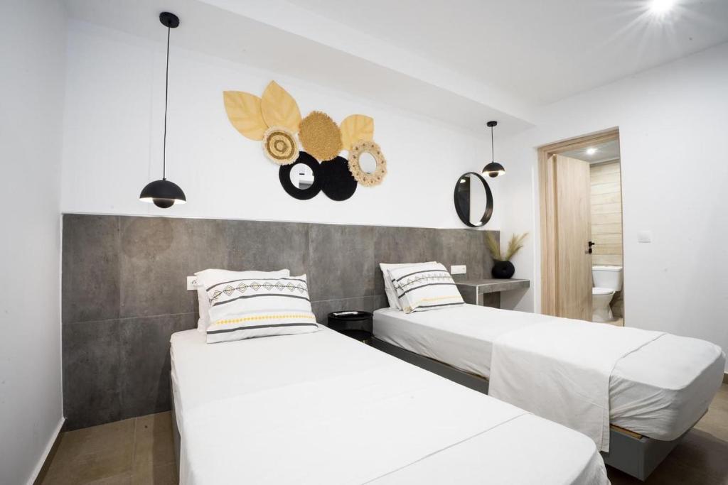 two beds in a room with white walls at Mousikorama Apartments in Faliraki