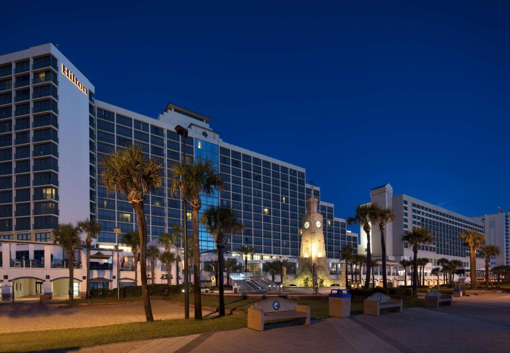 duży budynek z wieżą zegarową przed nim w obiekcie Hilton Daytona Beach Resort w mieście Daytona Beach