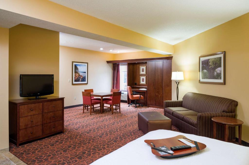 Habitación de hotel con sofá y comedor en Hampton Inn Selinsgrove/Shamokin Dam en Shamokin Dam