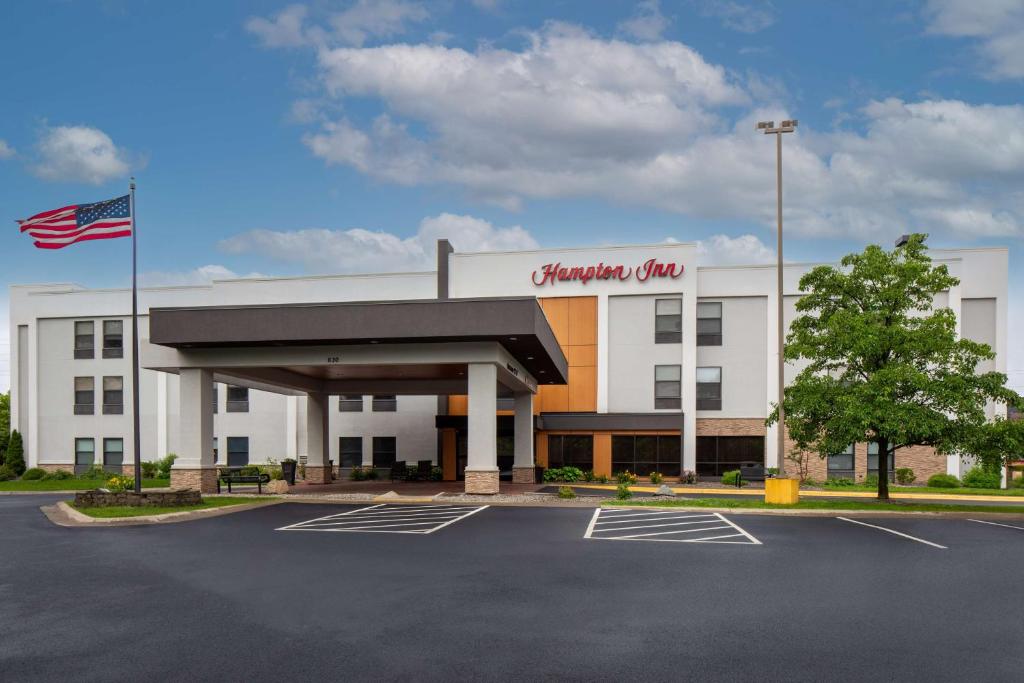 a shopping center with an american flag in a parking lot at Hampton Inn Binghamton/Johnson City in Binghamton