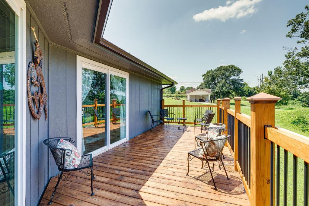 a deck with chairs and tables on a house at Guntersville Hideaway with Mountain and Lake Views! in Albertville