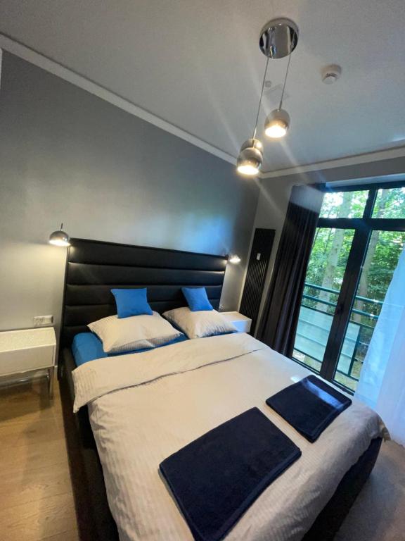 a bedroom with a large bed with blue and white pillows at Apartament Navy Blue z tarasem in Serock