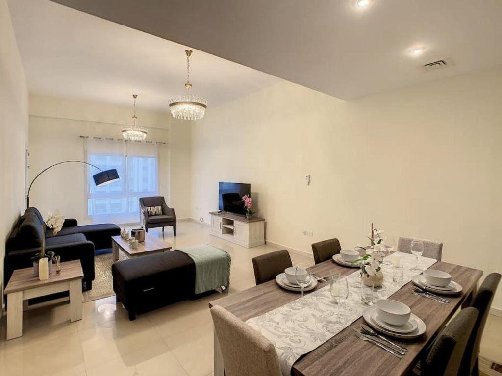 杜拜的住宿－Key View - Silicon Star，客厅配有餐桌和沙发