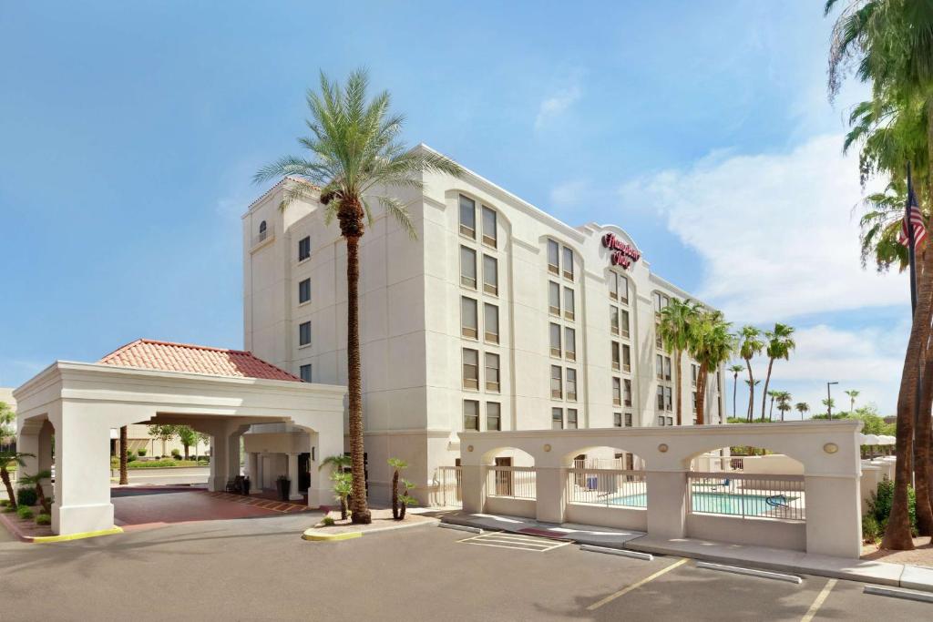 a hotel with a palm tree in a parking lot at Hampton Inn Phoenix-Chandler in Chandler
