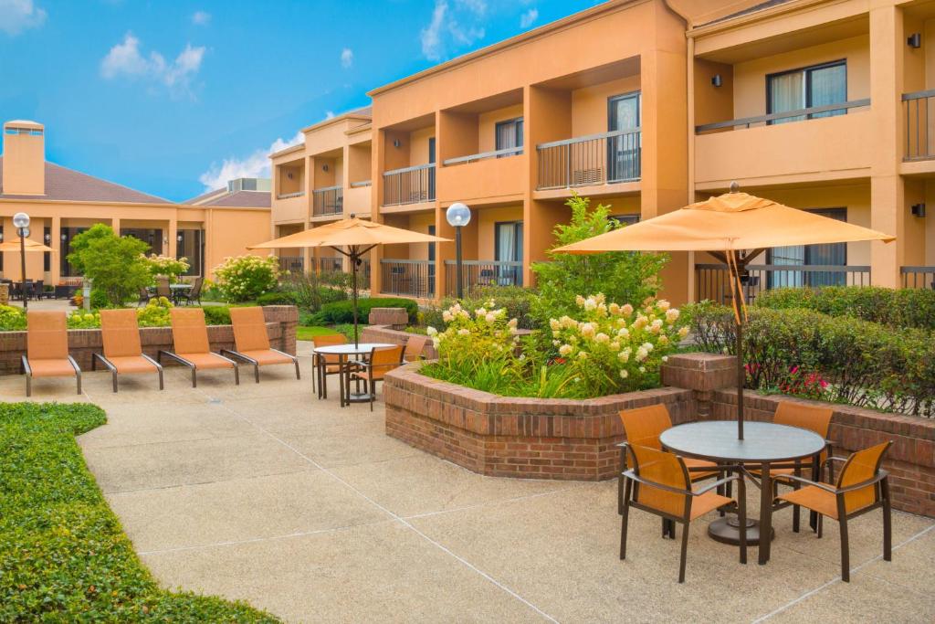 a patio with tables and umbrellas in front of a building at Courtyard Chicago Deerfield in Deerfield