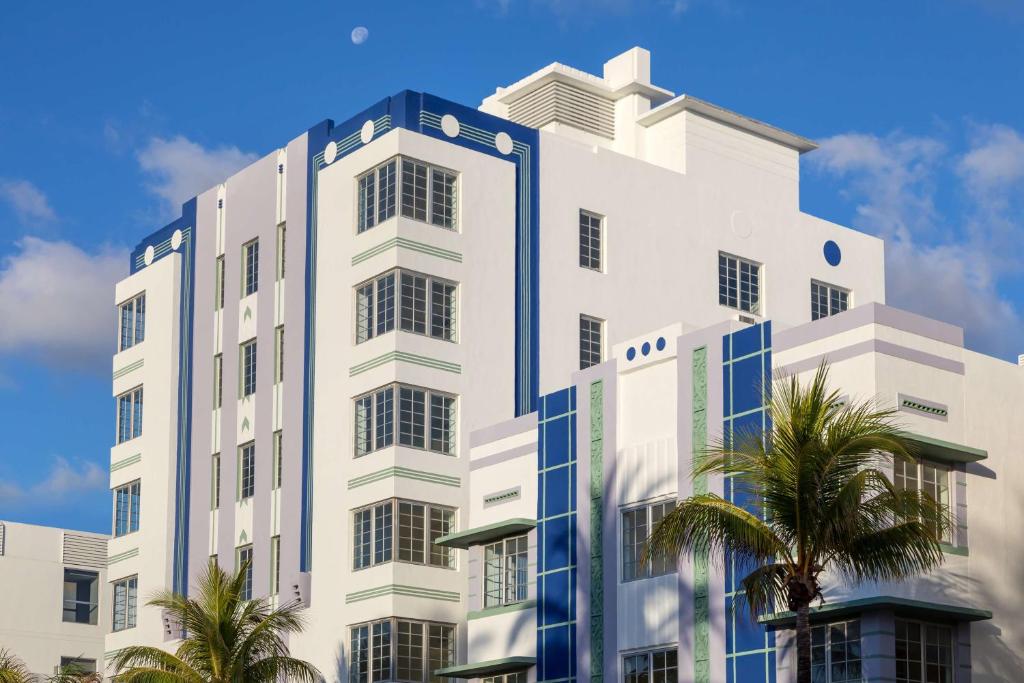 un grand bâtiment blanc avec des palmiers devant lui dans l'établissement The Gabriel Miami South Beach, Curio Collection by Hilton, à Miami Beach