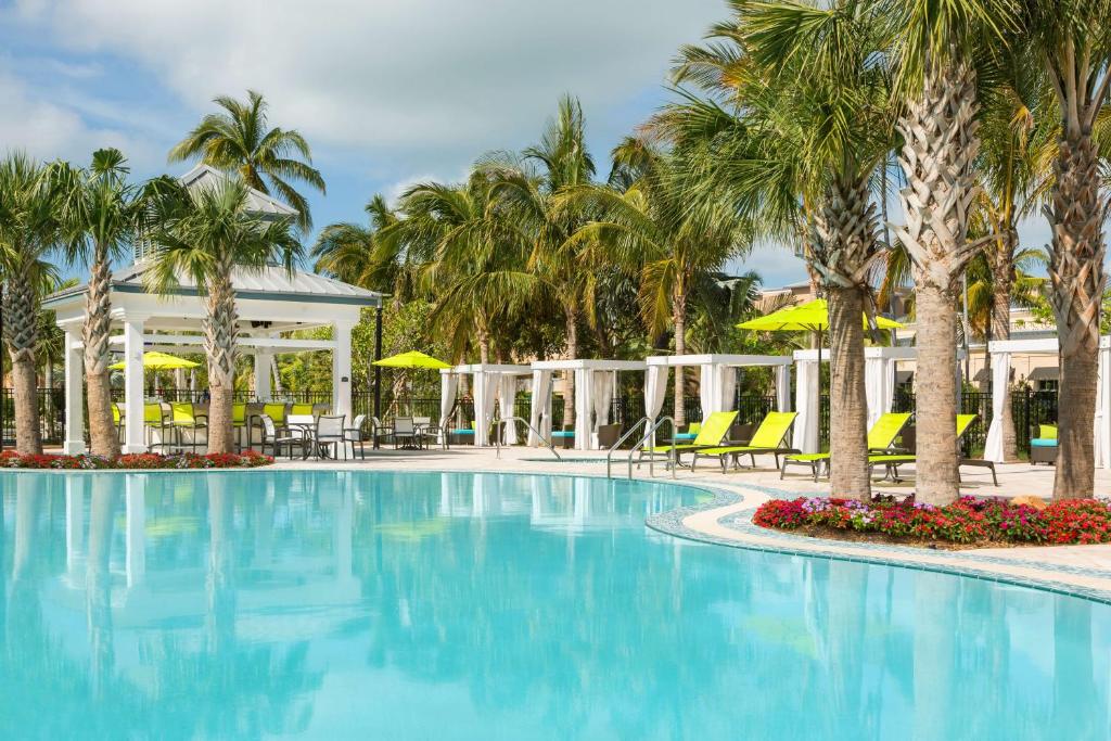 a pool at the resort with palm trees and chairs at Hilton Garden Inn Key West / The Keys Collection in Key West