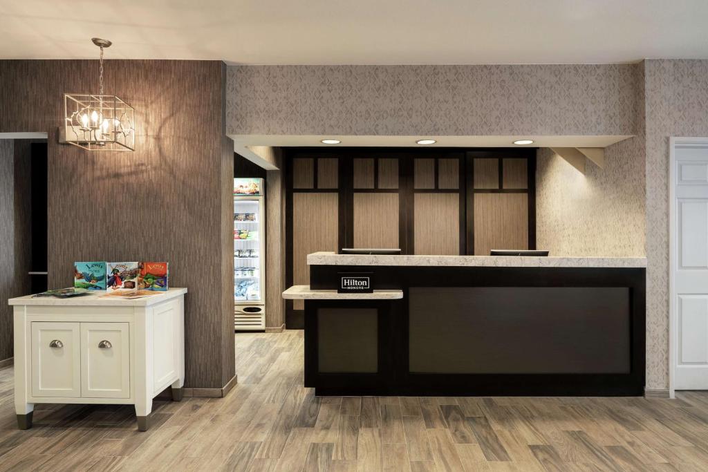 a kitchen with a black counter and a white island at Homewood Suites by Hilton Erie in Erie