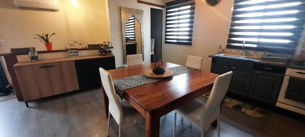 a kitchen with a wooden table with white chairs around it at Maison indisponible in Bages