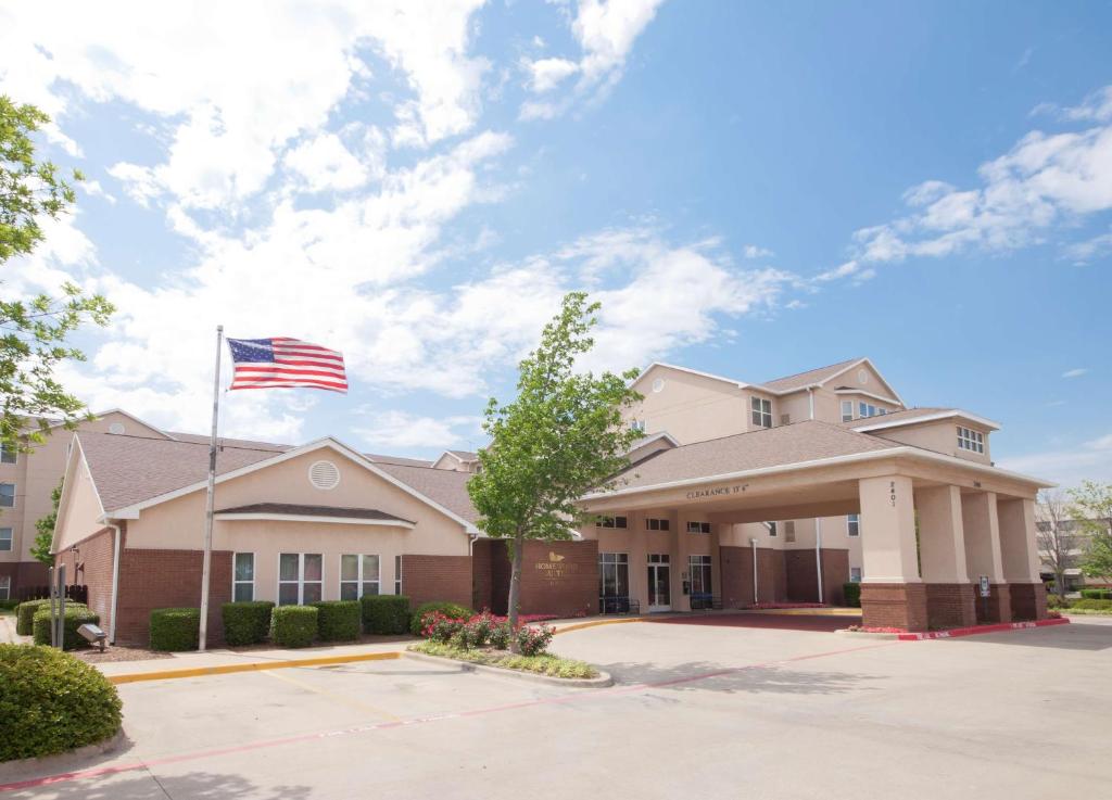 a building with an american flag in front of it at Homewood Suites by Hilton Dallas-Arlington in Arlington