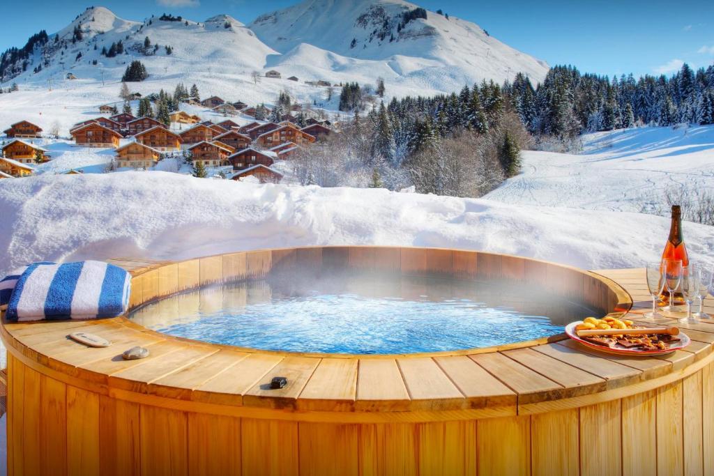 un bain à remous sur une terrasse dans la neige dans l'établissement Chalet Tolar - OVO Network, au Grand-Bornand