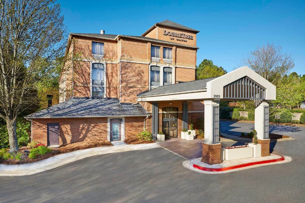 a large brick building with a parking lot in front of it at DoubleTree by Hilton Atlanta Alpharetta-Windward in Alpharetta