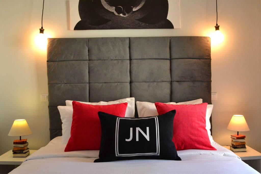 1 dormitorio con 1 cama con almohadas rojas y negras en JN Boutique Apartments, en Bucarest