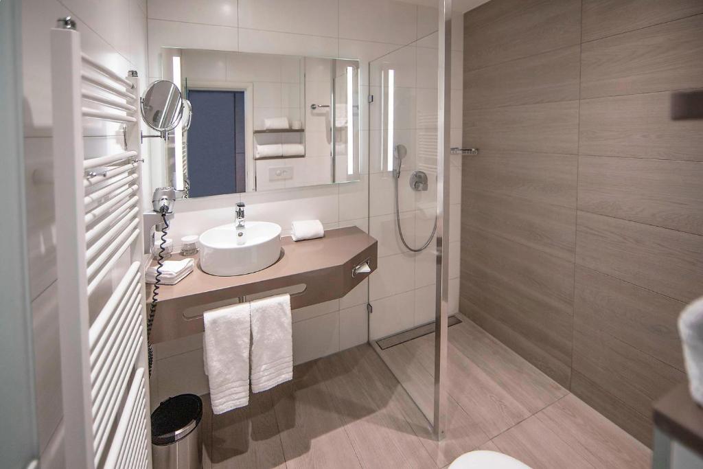 a bathroom with a sink and a shower at Apollo Hotel Amsterdam, a Tribute Portfolio Hotel in Amsterdam