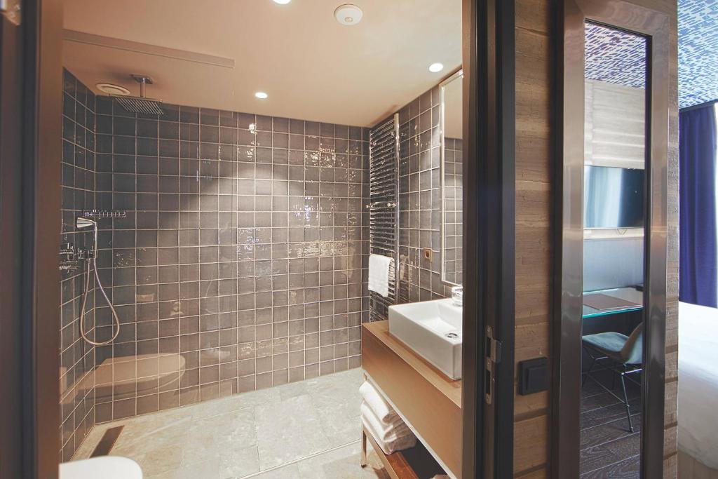 a bathroom with a sink and a shower at Apollo Hotel Amsterdam, a Tribute Portfolio Hotel in Amsterdam