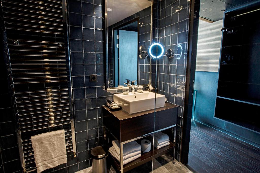 a bathroom with a sink and a mirror at Apollo Hotel Amsterdam, a Tribute Portfolio Hotel in Amsterdam