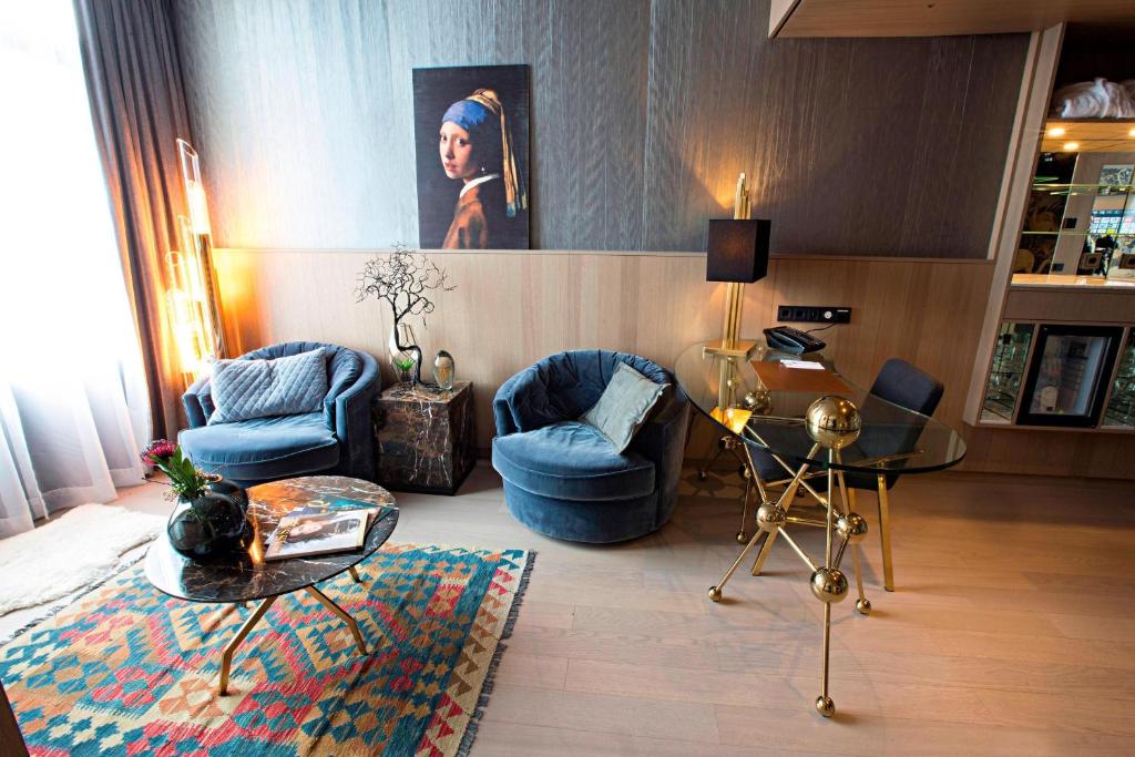 a living room with two chairs and a table at Apollo Hotel Amsterdam, a Tribute Portfolio Hotel in Amsterdam