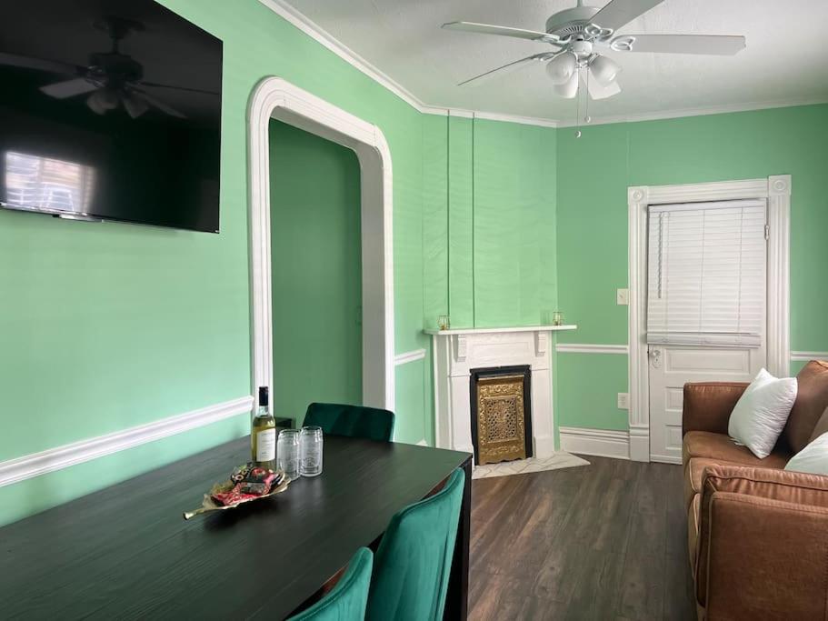 a living room with green walls and a fireplace at Cosy 3-Bedroom Downtown Walk to Convention Center in Tampa