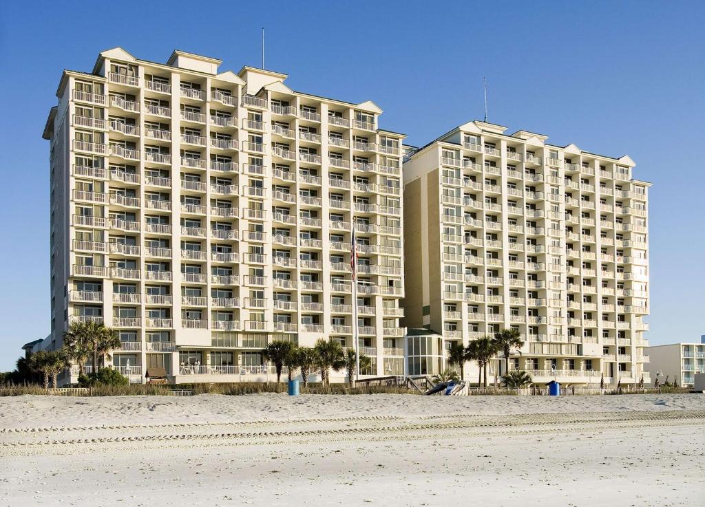 a large building on the beach next to the beach at Hampton Inn & Suites Myrtle Beach Oceanfront in Myrtle Beach